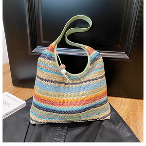 Detail of colorful striped woven tote bag with green leather handles and bead charms