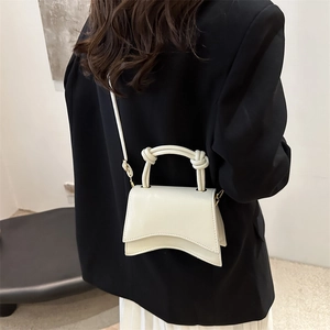 Minimalist cream white leather hourglass handbag with curved base and twisted handle