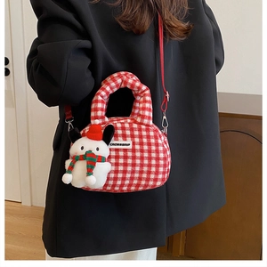 Detail der rot-weiß karierten Plüschtasche mit niedlichem Hunde-Plüschanhänger