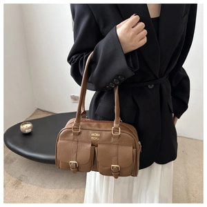 Detail of vintage brown PU leather tote bag with two front pockets and gold buckle accents