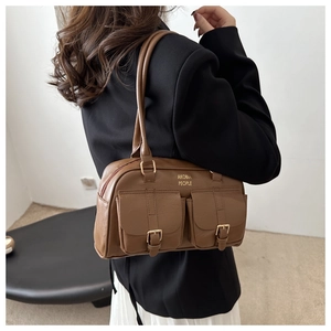 Detail of vintage brown leather Boston bag showing dual front flap pockets and metal buckles