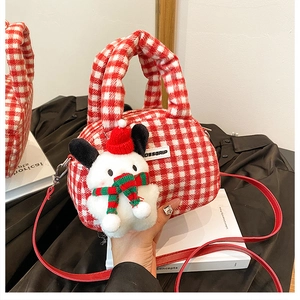 Detail der rot-weißen Plüschhandtasche mit süßem Weihnachts-Welpen-Anhänger