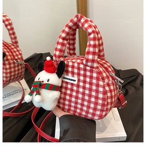 Detail der rot-weiß karierten Plüschhandtasche mit festlichem Welpenanhänger und Riemen