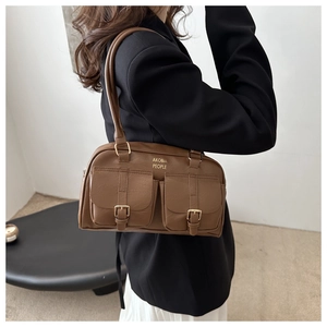 Detail of vintage brown pillow shoulder bag with metal buckles and brand logo
