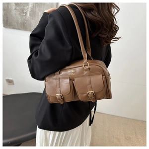 Detail shot of vintage brown pillow bag showing dual front flap pockets and golden hardware