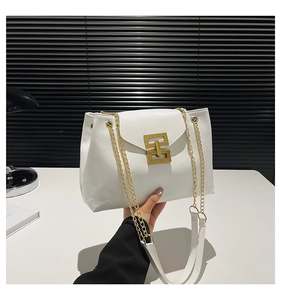Detail of white leather shoulder bag with gold rectangular metal buckle and chain strap