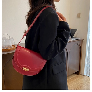 Modella con borsa a sella vintage in pelle rossa e fibbia metallica dorata