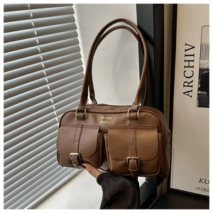 Detail of vintage brown pebble leather shoulder bag with two utility front buckled pockets