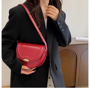 Borsa a sella rossa vintage con chiusura dorata su una giacca blazer nera