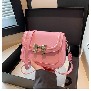 Detailansicht der rosa Umhängetasche mit goldener Schleifenschnalle in einer Geschenkbox