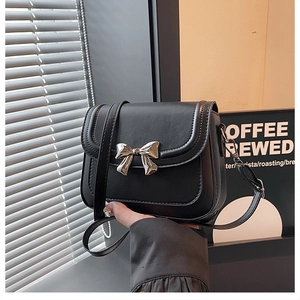 Detail einer schwarzen matten Ledertasche mit silberner Metallschleife