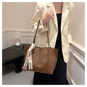 Braune Leder-Tote-Bag mit vertikaler Naht und Elfenbein-Schleife am Henkel befestigt
