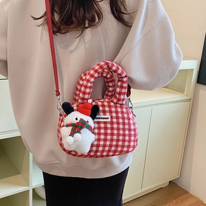 Rote und weiße Gingham-Umhängetasche mit süßem Schneemann-Plüschanhänger an einem Model