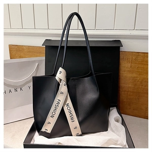 Details einer schwarzen Tote Bag aus Leder mit Modeband in einer edlen Geschenkbox