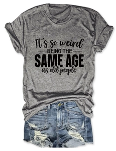 Détail de l'imprimé slogan sur un T-shirt gris porté avec un short en jean déchiré