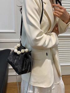 Black textured cloud bag with large marble bead handle and metal chain strap on model