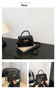 Détail du sac bandoulière noir avec boucle nœud doré et finition en PU texturé