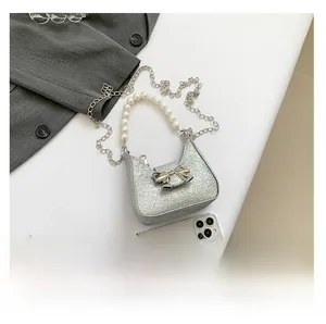 Detail of silver sequin bag with pearl handle and metallic bow buckle and chain strap