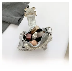 Macro view of silver sequin bag interior with pearl handle and metal bow closure