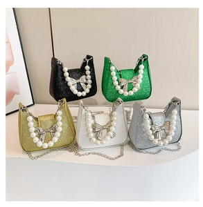 Detail of mini sequin handbags with pearl handles and silver metal bow accents