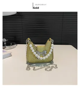 Detail of gold sequin saddle bag with silver bow ornament and pearl handle strap