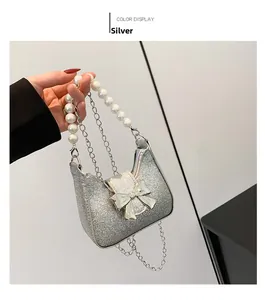 Detailed shot of silver sequin mini bag with pearl handle and bow decoration