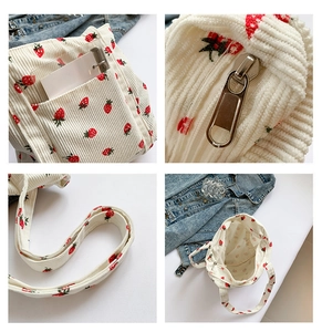 Detail view of corduroy tote bag featuring strawberry prints and zip closure