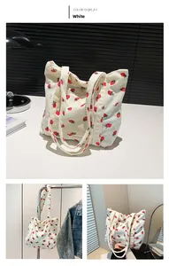 Detail of white corduroy tote bag with red strawberry print and sturdy double handles