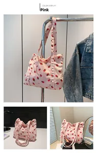 Pink corduroy tote bag featuring red strawberry patterns and double shoulder straps