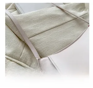 Detail of light pink shoulder bag showing neat stitching and strap attachment point