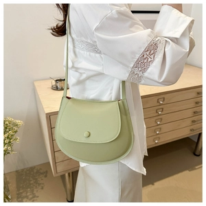 Detailed view of a mint green crescent crossbody bag with smooth matte leather finish