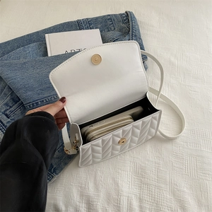 Internal view of a white quilted crossbody bag showing capacity for phone and wallet