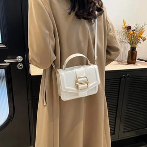 Minimalist white leather crossbody bag with elegant gold metal buckle and top handle