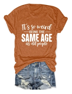 T-shirt caramel avec texte et short en jean vieilli posé à plat sur fond blanc