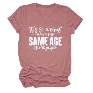 Détail du t-shirt mauve à col rond avec citation humoristique et manches retroussées
