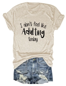 Detail eines beigen T-Shirts mit Spruch und blauer Jeansshorts mit Distressed-Effekt