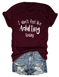 Detail eines weinroten T-Shirts mit weißem Text und blauen Jeansshorts im Flat-Lay-Stil