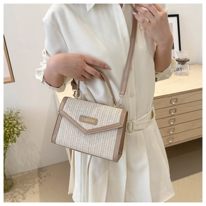 Sac bandoulière en paille avec plaque dorée FASHION porté sur une tenue élégante