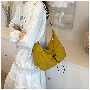 Ginger yellow crescent tote bag with adjustable shoulder strap and drawstring detail