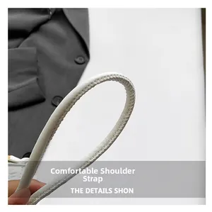 Detail of comfortable white leather shoulder strap with precise stitching on a trendy bag
