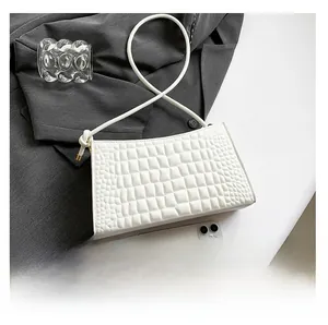 Top view of white crocodile pattern bag showing size comparison with a smartphone