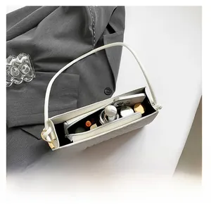 Internal structure of white baguette bag showing zip pocket and daily essentials capacity