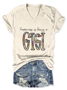 Flat lay of beige V-neck T-shirt with GIGI floral print and blue distressed denim shorts