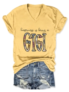 Flat lay of a mustard yellow V-neck GIGI t-shirt tucked into ripped denim shorts