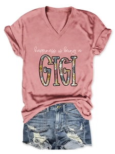 Flat lay of a dusty rose V-neck T-shirt with GIGI floral print and ripped denim shorts