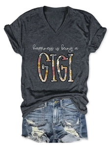 Flat lay of a grey V-neck t-shirt with GIGI floral text and distressed denim shorts