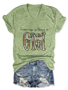 Flat lay of a green V-neck T-shirt with GIGI print and distressed denim shorts