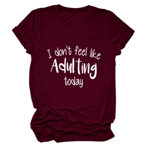 Detail eines burgunderroten Baumwoll-T-Shirts mit dem weißen Aufdruck I don't feel like Adulting