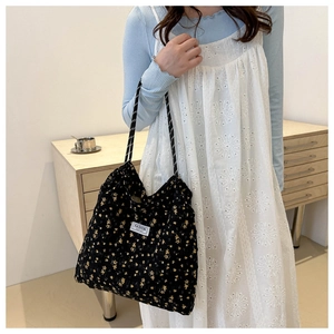 Detail of floral nylon tote bag with fashion label and braided rope shoulder strap