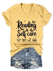 Flat lay of yellow Reading is Self care V-neck T-shirt with denim shorts and butterfly print